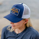 Outsider Authentic Goods Blue, White, and Yellow Adjustable Snapback Hat worn by a woman